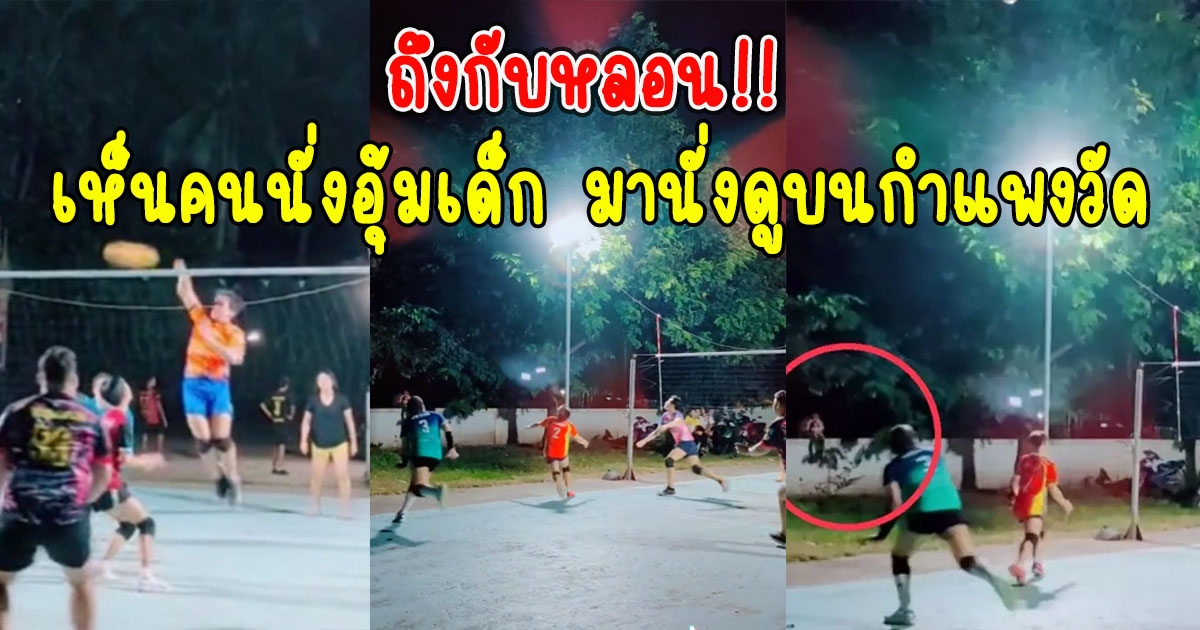 หนุ่มๆกำลังเล่นวอลเลย์บอล เห็นคนนั่งอุ้มเด็ก มานั่งดูบนกำแพงวัด